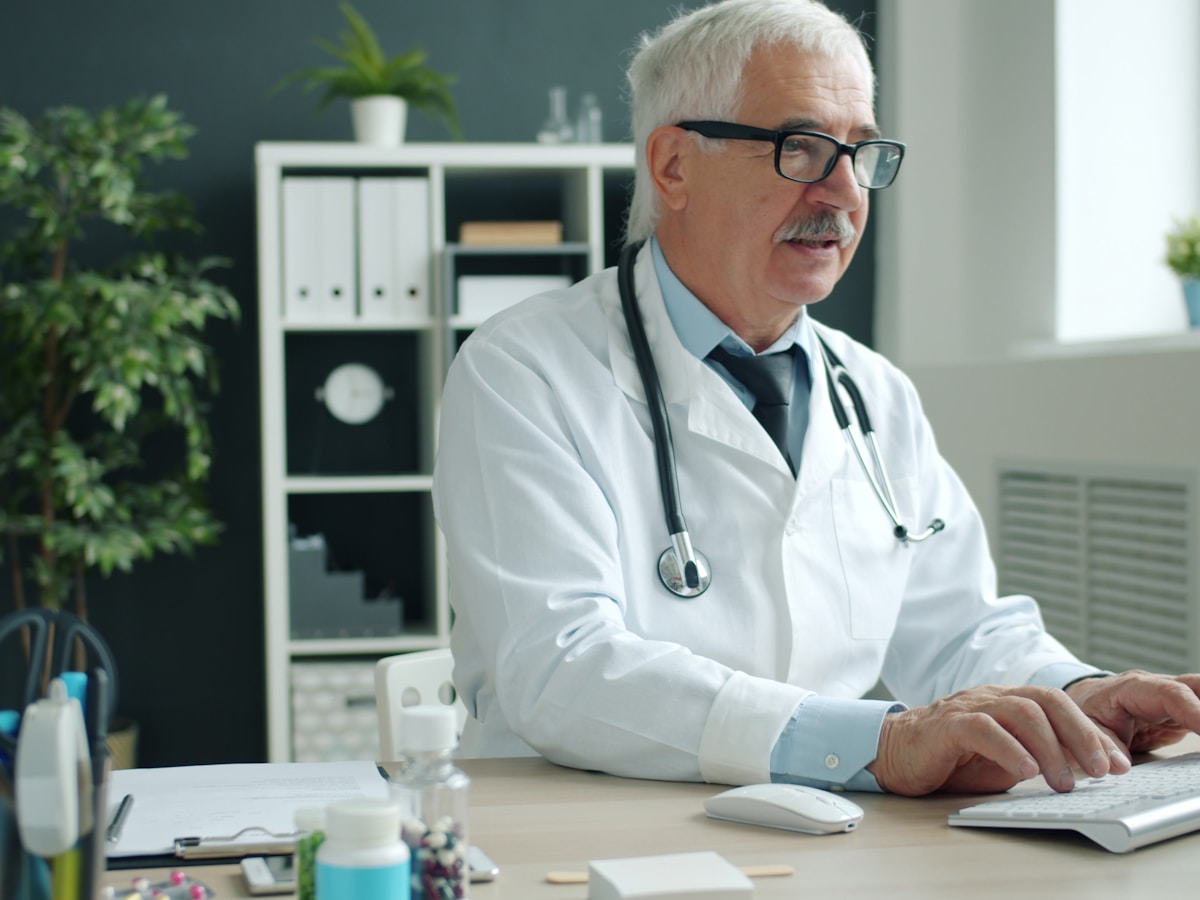 Doctor using desktop computer in office